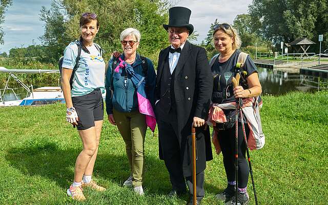 <p>Drei Frauen in sportlicher Kleidung posieren mit einem als Theodor Fontane verkleideten Mann für die Kamera.</p>