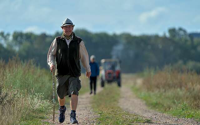 Wanderer in bayrischer Tracht auf einem Feld